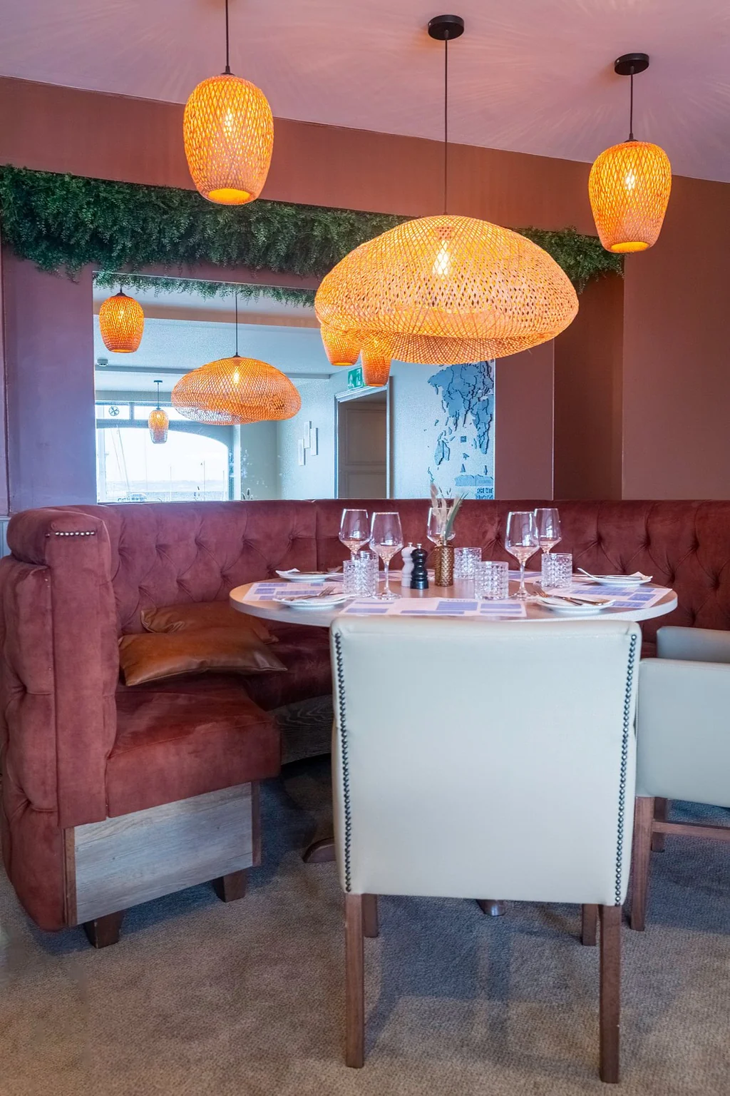 A lively bar scene features a group of people engaged in various activities, with a man playing guitar and a woman singing. The bar has a warm ambiance with hanging lamps and a television mounted on the wall. The atmosphere is casual and relaxed, with people enjoying drinks and engaging in conversation.