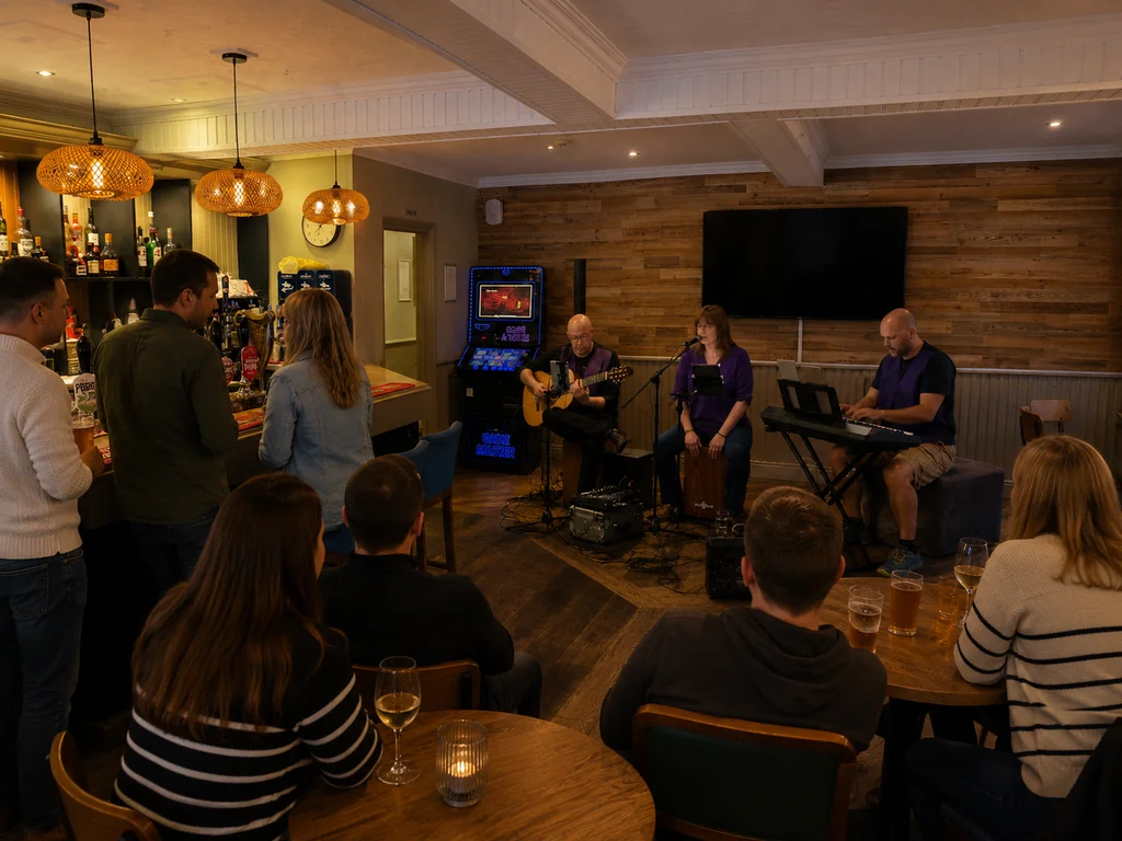 A lively bar scene features a group of people engaged in various activities, with a man playing guitar and a woman singing. The bar has a warm ambiance with hanging lamps and a television mounted on the wall. The atmosphere is casual and relaxed, with people enjoying drinks and engaging in conversation.